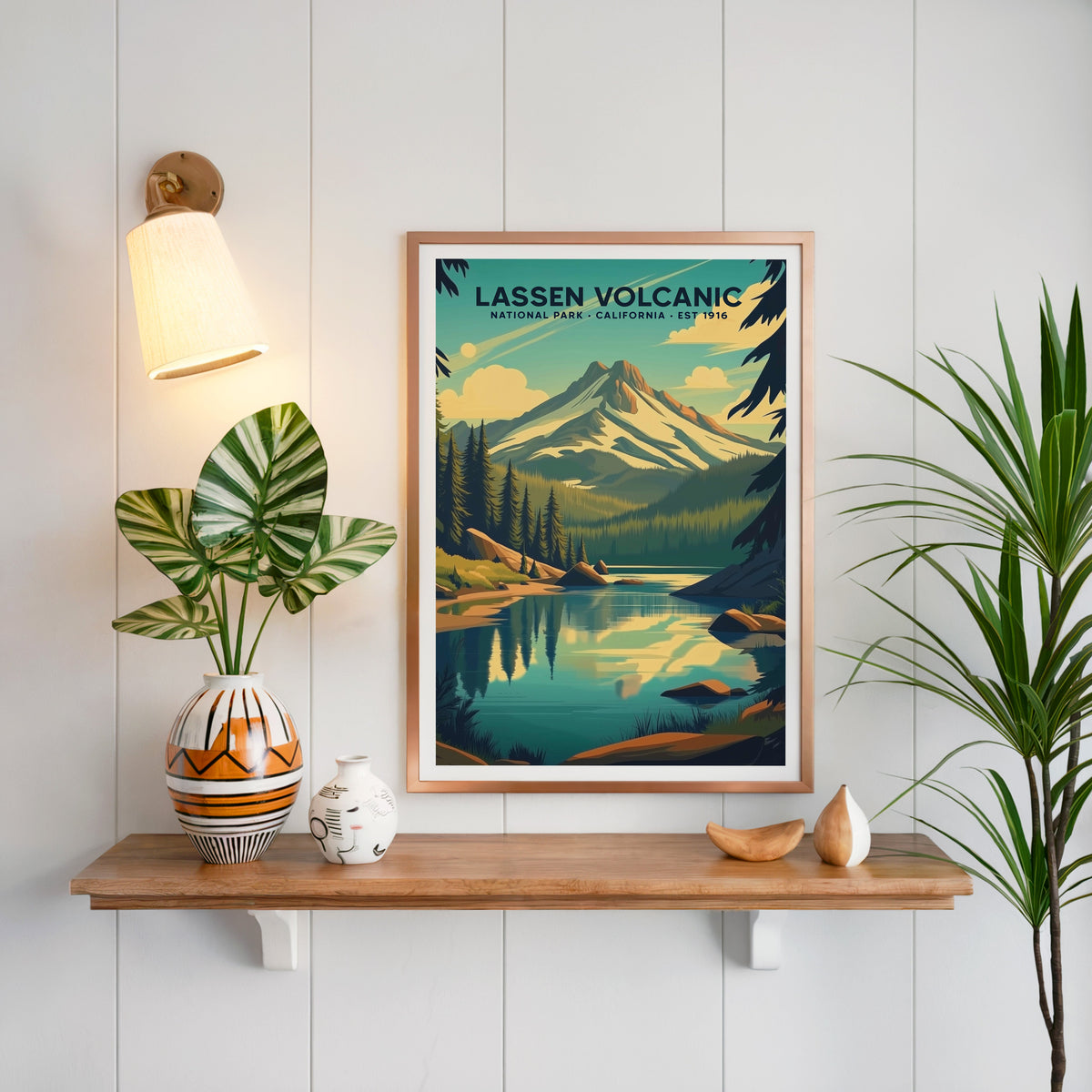 Lassen Volcanic National Park print in a copper frame above an oak shelf on white shiplap with a brass sconce