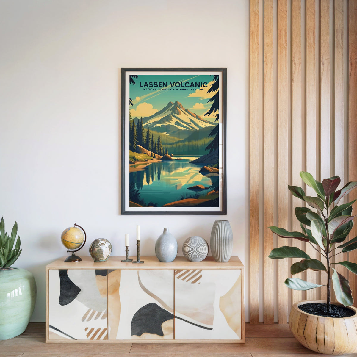 Lassen Volcanic National Park print in a black frame above a light wood sideboard with a globe and ceramic vases