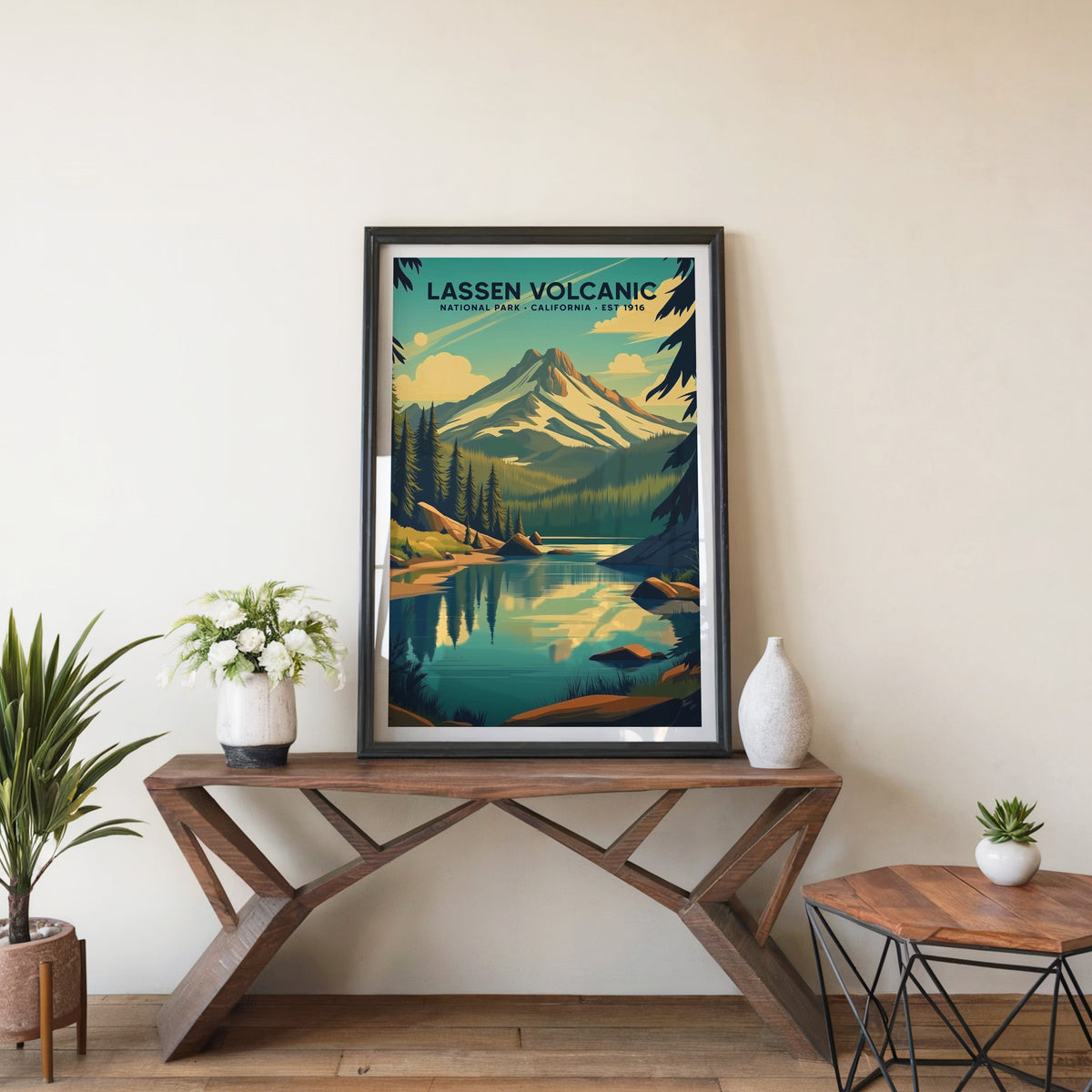 Lassen Volcanic poster in a black frame on an entryway console table beside white flowers and a yucca