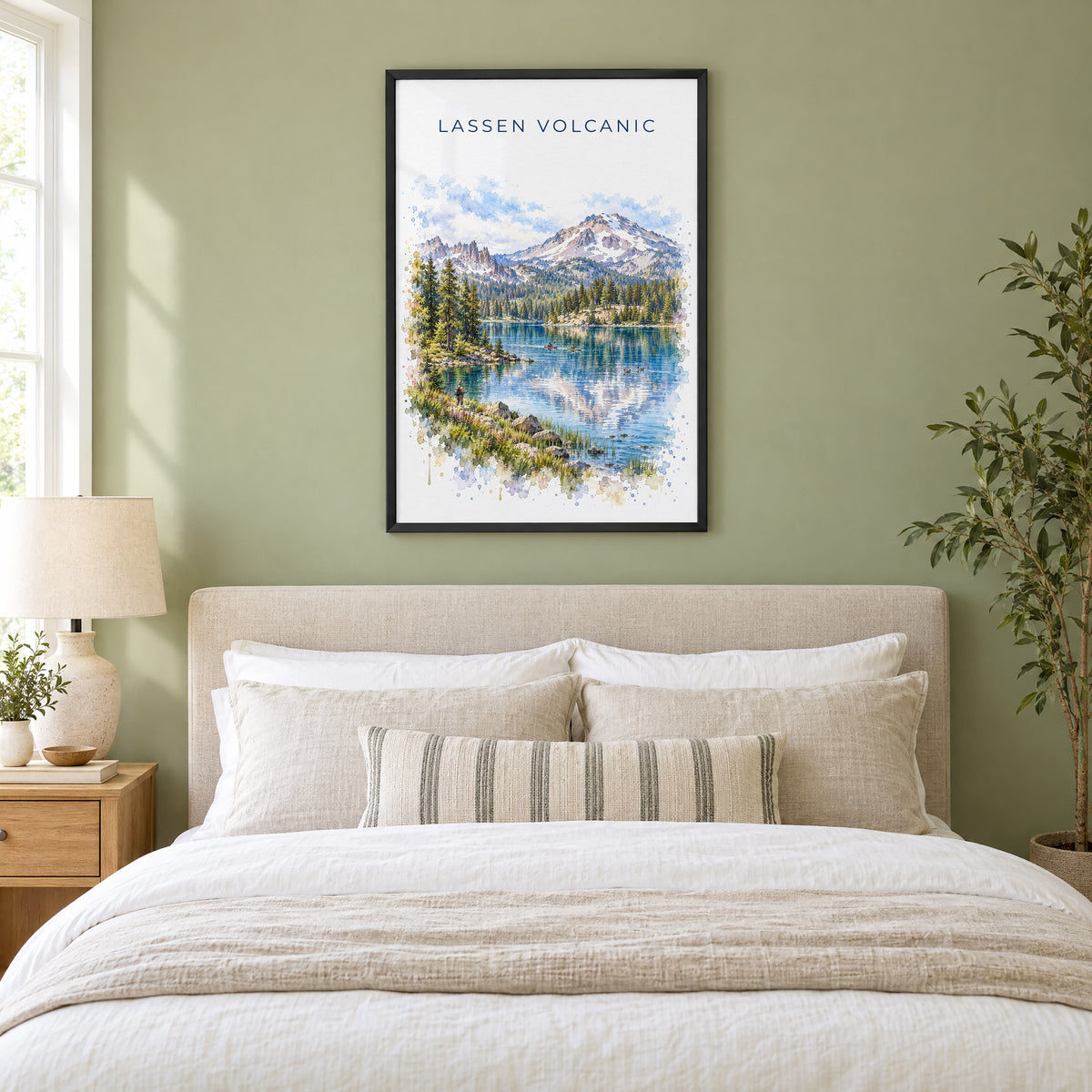 Lassen Volcanic National Park watercolor print in a black frame above an upholstered headboard in a sage green bedroom