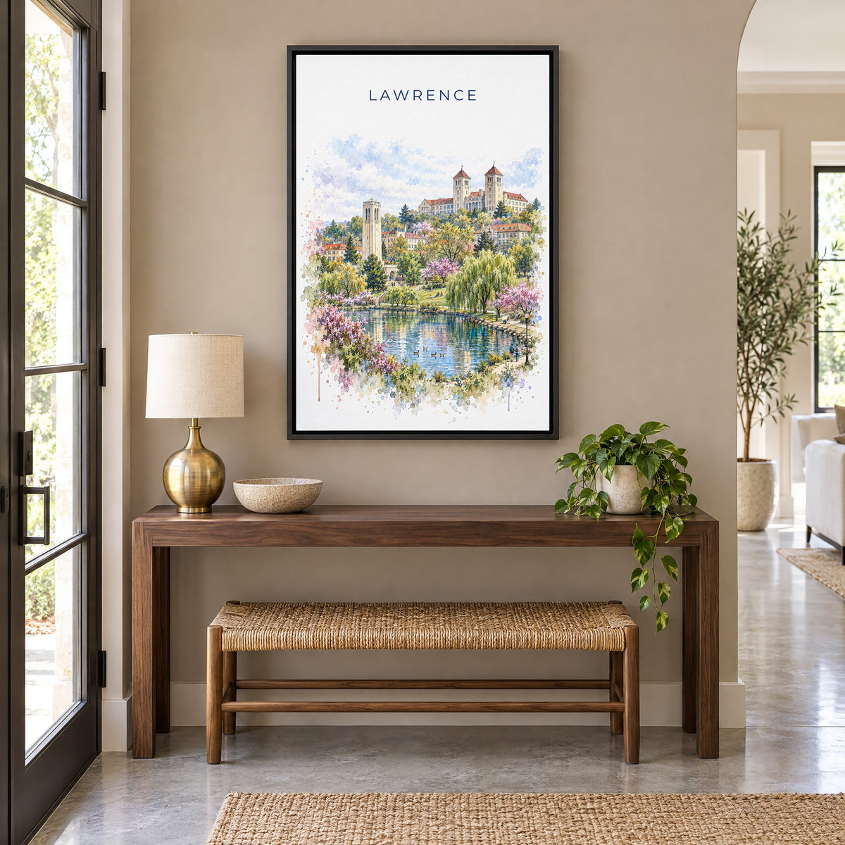 Lawrence, Kansas watercolor print as a black floater canvas above a walnut console and woven bench in an entryway