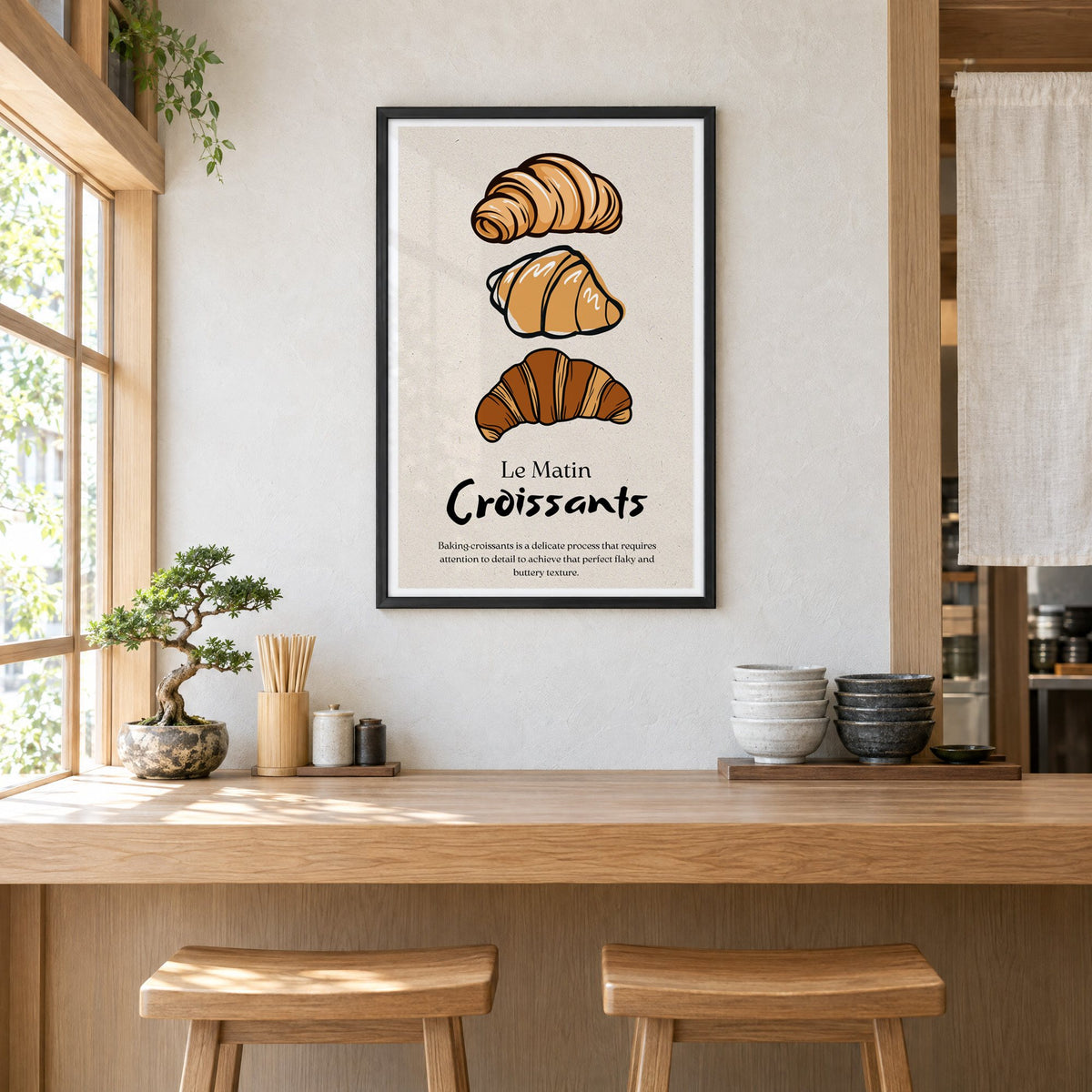 Le Matin Croissants three croissants print in a black frame above a light wood ramen counter with stools and stacked bowls