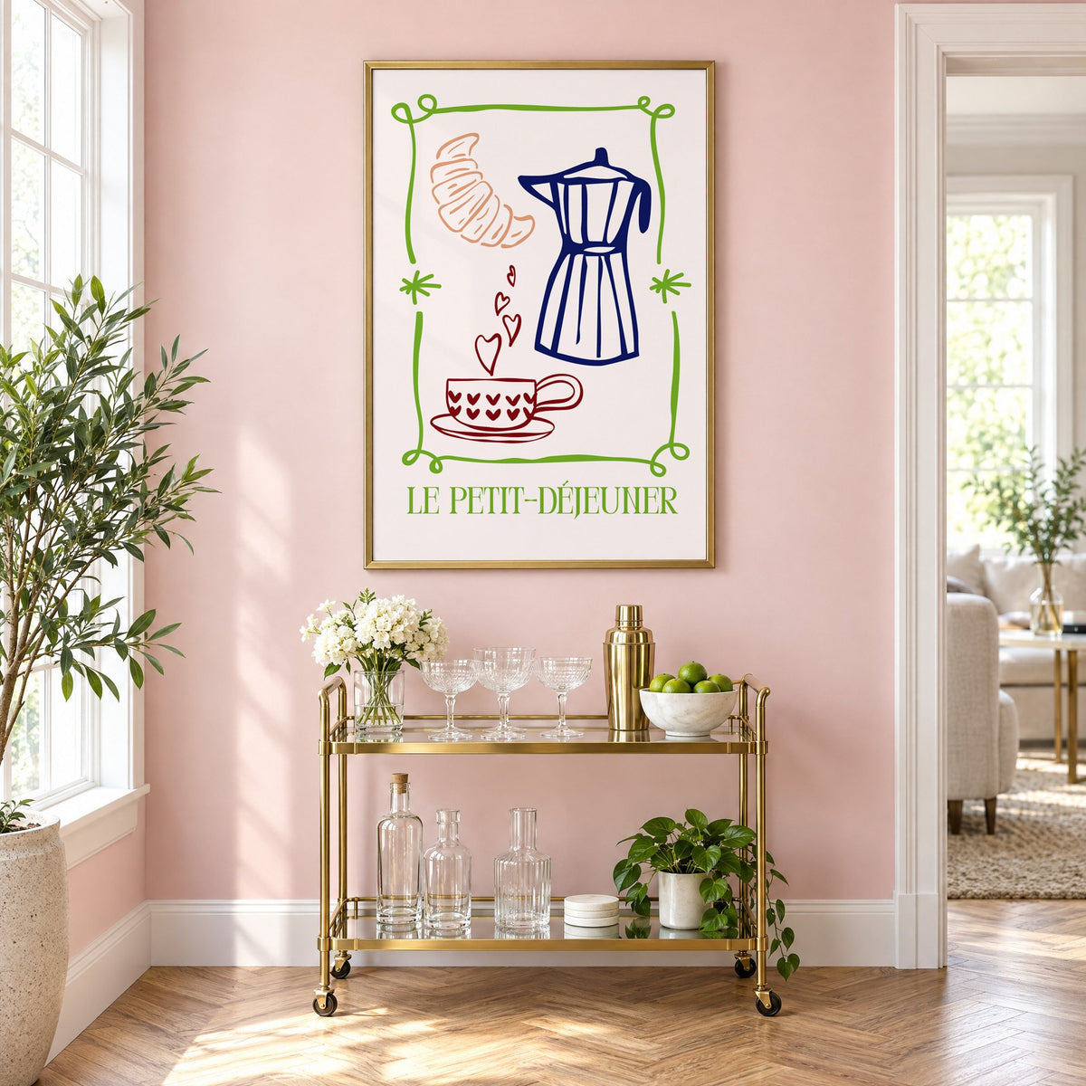 LE PETIT-DÉJEUNER moka pot and croissant print in a brass frame on a blush pink wall above a gold bar cart with glassware