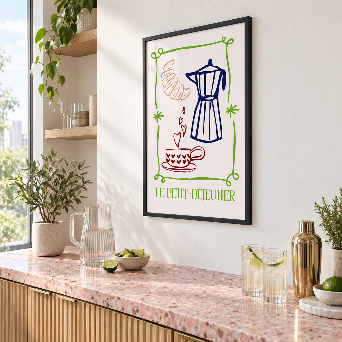 LE PETIT-DÉJEUNER moka pot and croissant print in a black frame above a pink terrazzo cocktail counter with limes, seen at an angle