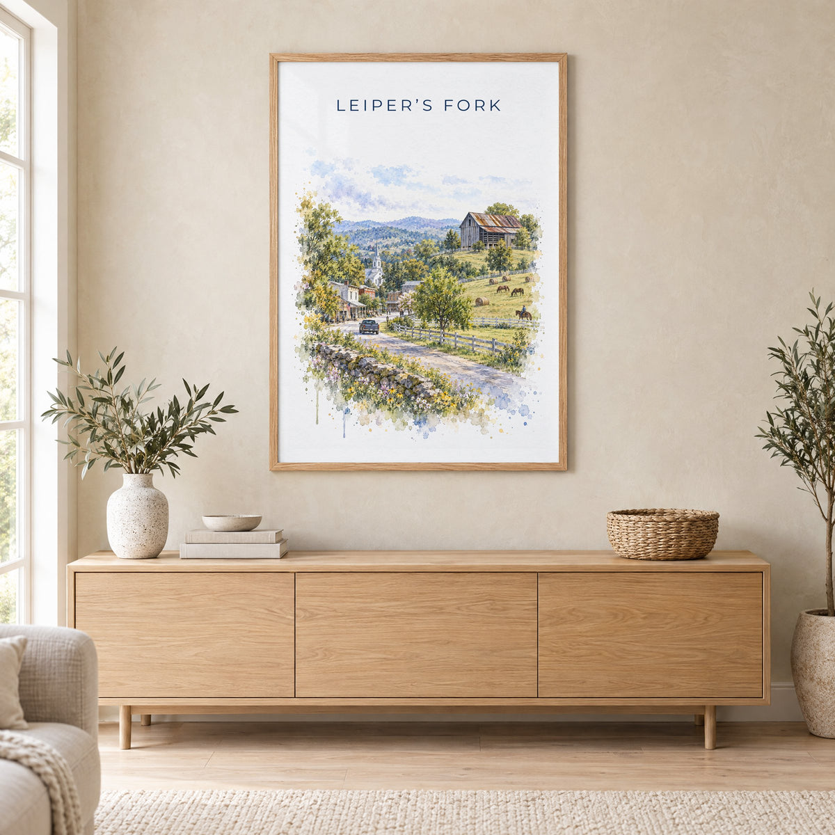 Leiper's Fork, Tennessee watercolor print in an oak frame above a light wood sideboard in a Scandinavian living room
