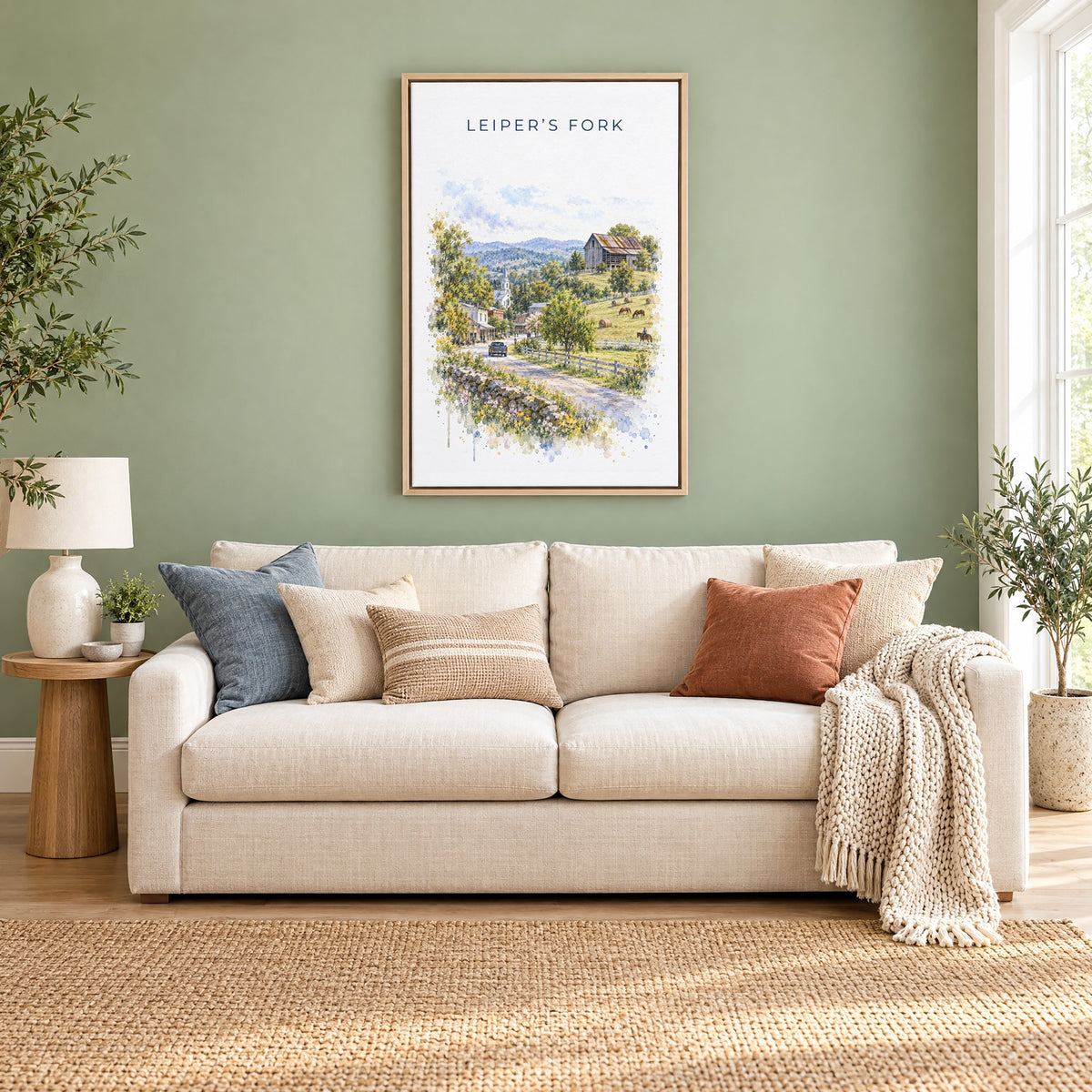 Leiper's Fork, Tennessee watercolor print as a natural floater canvas above a cream linen sofa on a sage green wall