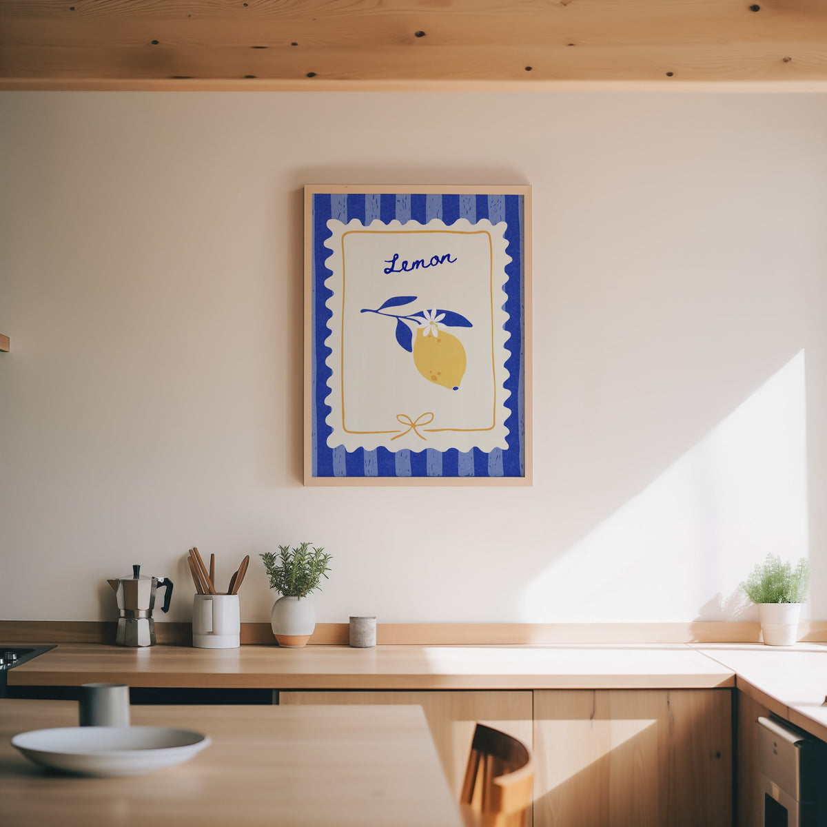 Lemon branch print in an oak frame above a wood counter with a moka pot and herbs