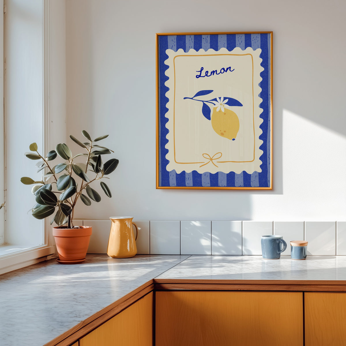 Lemon branch print in a gold frame above a marble counter with a yellow ceramic jug