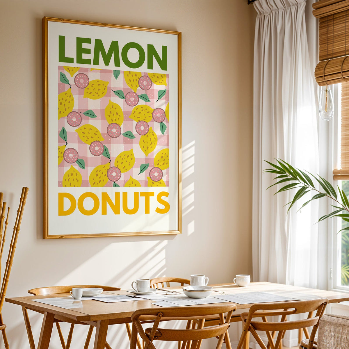 Lemon and donuts print shown in a gold frame above a breakfast table by a curtained window