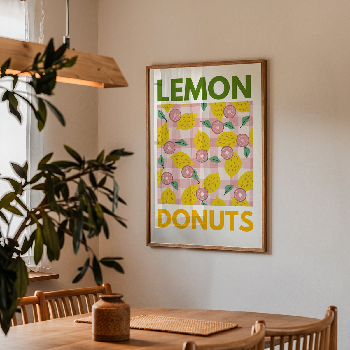 Lemon and donuts print in a walnut frame above a dining table with olive branches