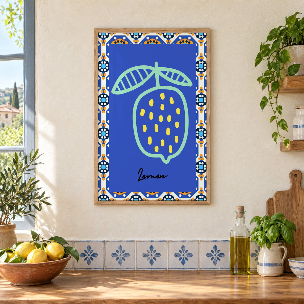 Lemon mint outline cobalt tile print in an oak frame on a cream plaster wall above a worktop with a bowl of lemons and blue-and-white tiles