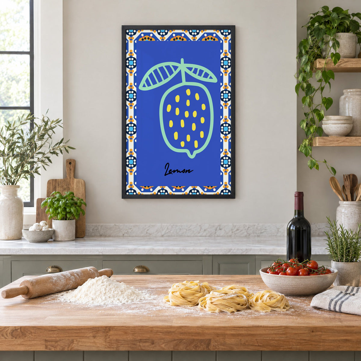 Lemon mint outline cobalt tile print in a black frame above a butcher-block island with fresh pasta, flour and cherry tomatoes