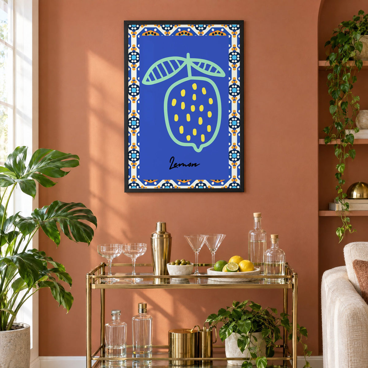 Lemon mint outline cobalt tile print in a black frame on a terracotta wall above a brass bar cart with coupes and citrus