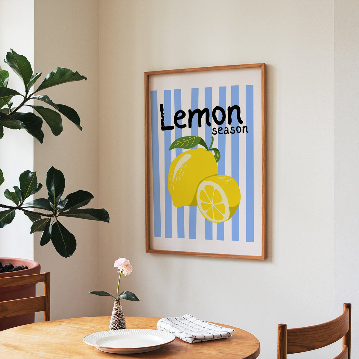 Lemon Season print in a walnut frame above a round table beside a fiddle-leaf fig