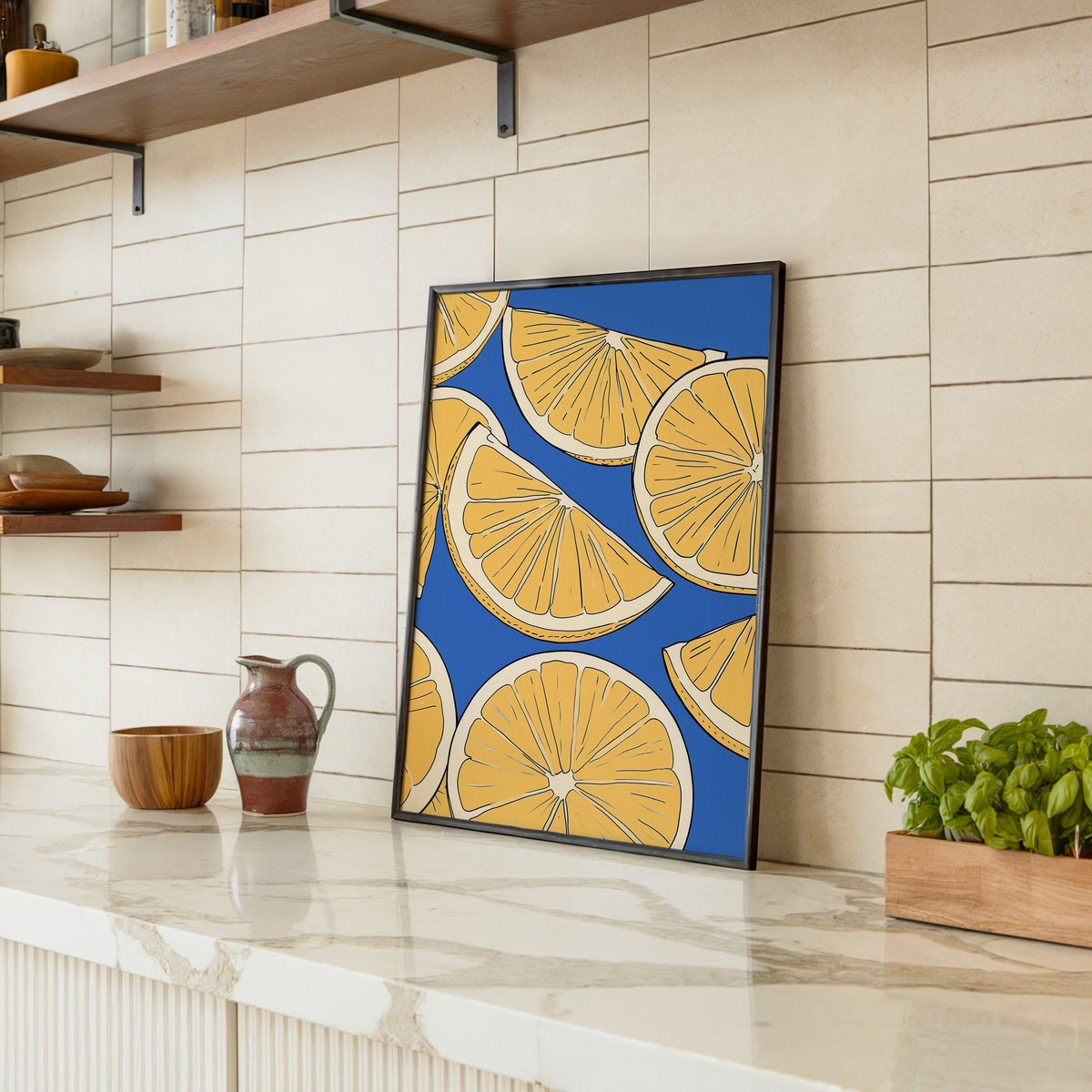 Lemon slice pattern print in a black frame leaning on a marble counter in a tiled kitchen