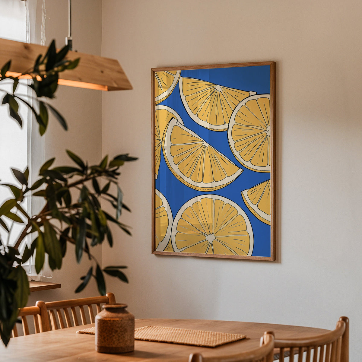 Lemon slice pattern print in a walnut frame above a dining table with olive branches