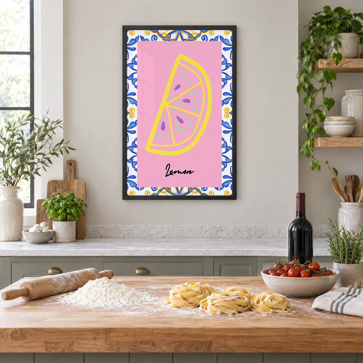 Lemon slice pink majolica tile print in a black frame above a butcher-block island with fresh pasta, flour and cherry tomatoes