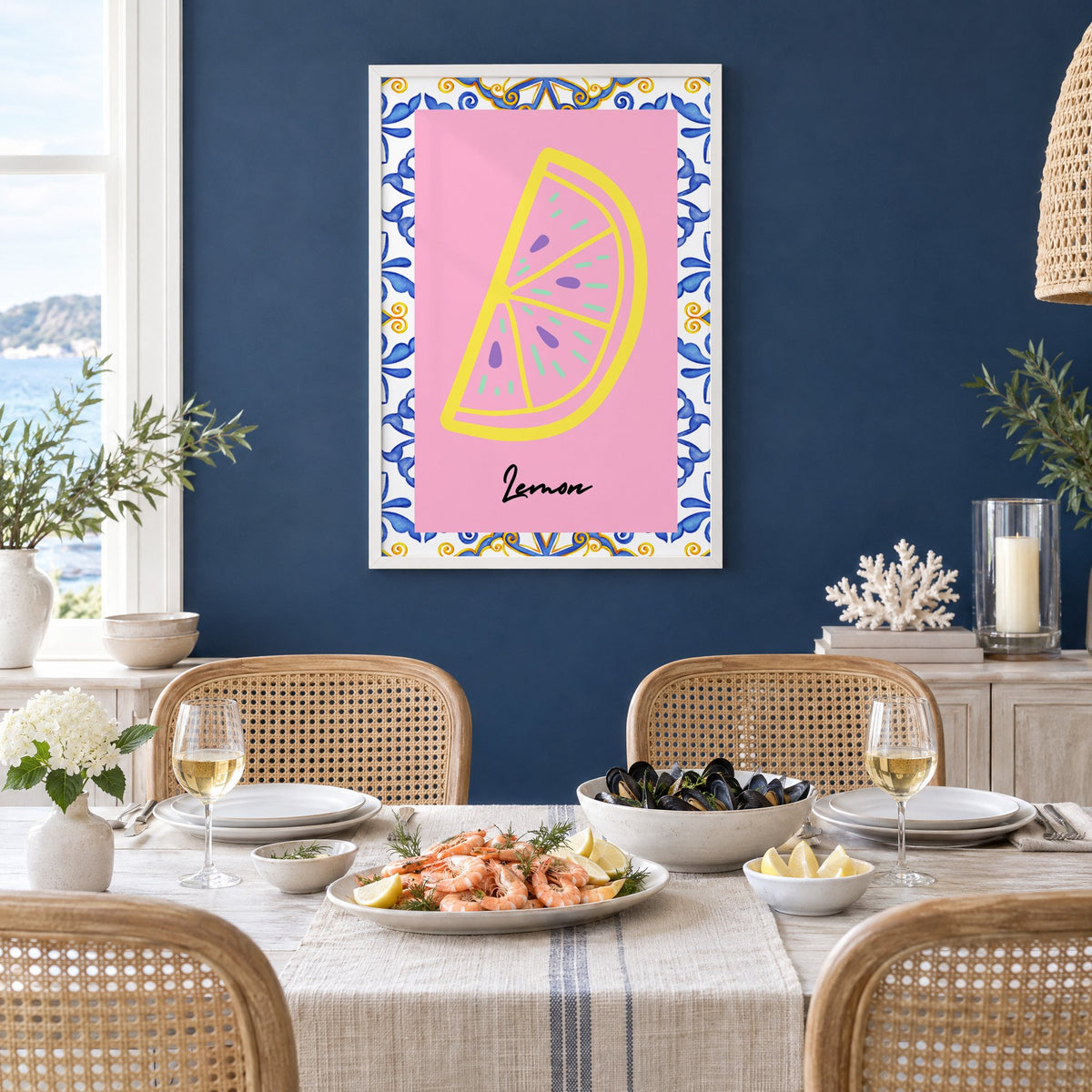 Lemon slice pink majolica tile print in a white frame on a navy wall above a dining table set with shrimp and mussels