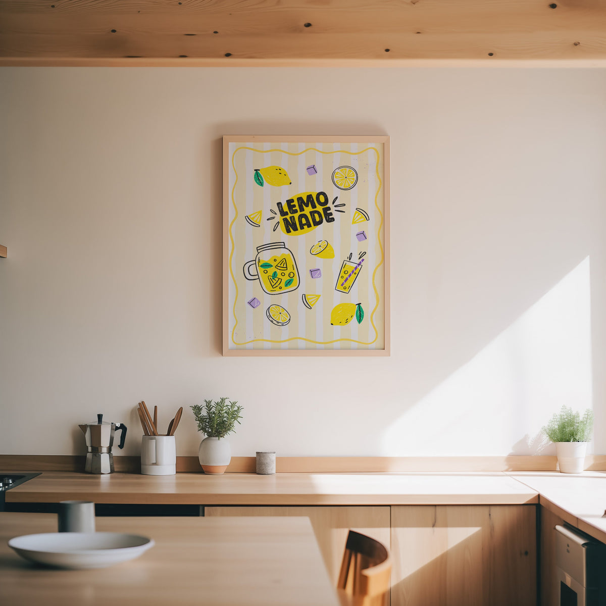 Lemonade print in an oak frame above a wood counter with a moka pot and herbs