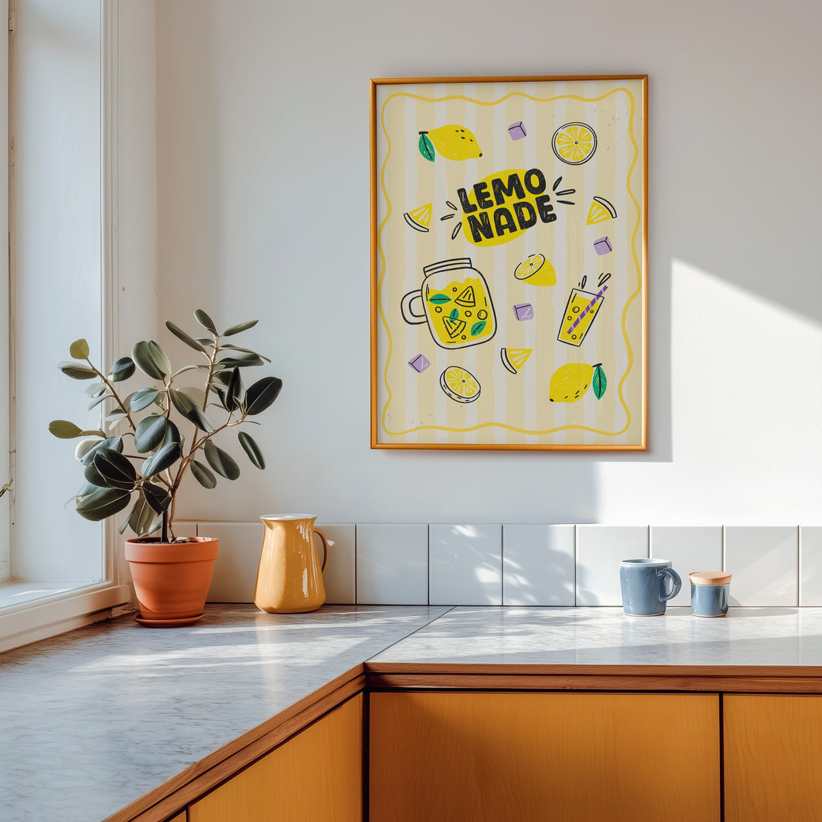 Lemonade print in a gold frame above a marble counter with a yellow ceramic jug