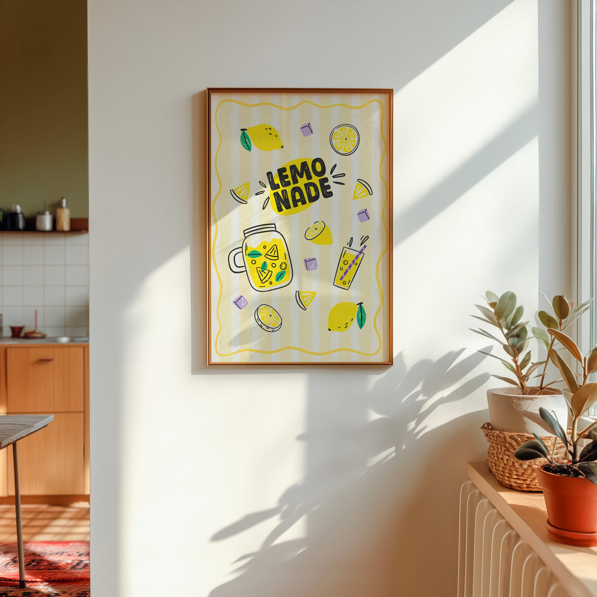 Lemonade print in a gold frame in sunlight with plants and a kitchen beyond