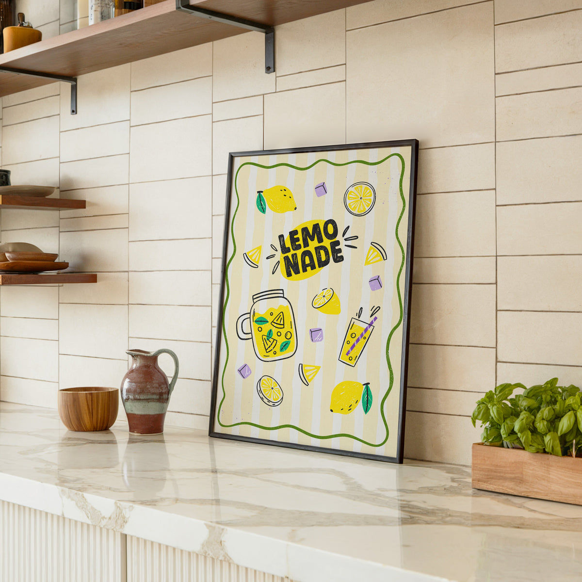 Lemonade Stand print in a black frame leaning on a marble counter in a tiled kitchen