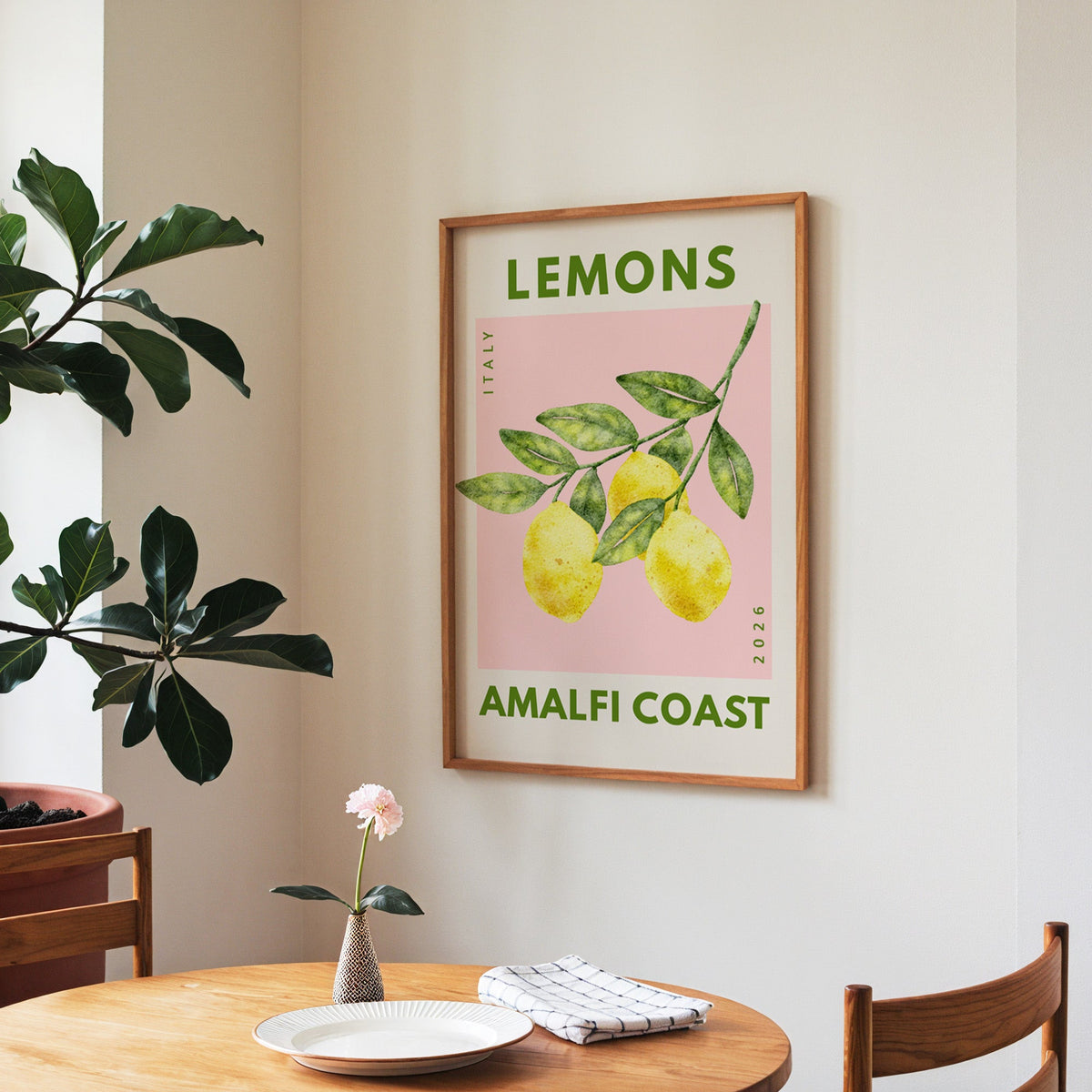 Lemons Amalfi Coast print in a walnut frame above a round table beside a fiddle-leaf fig