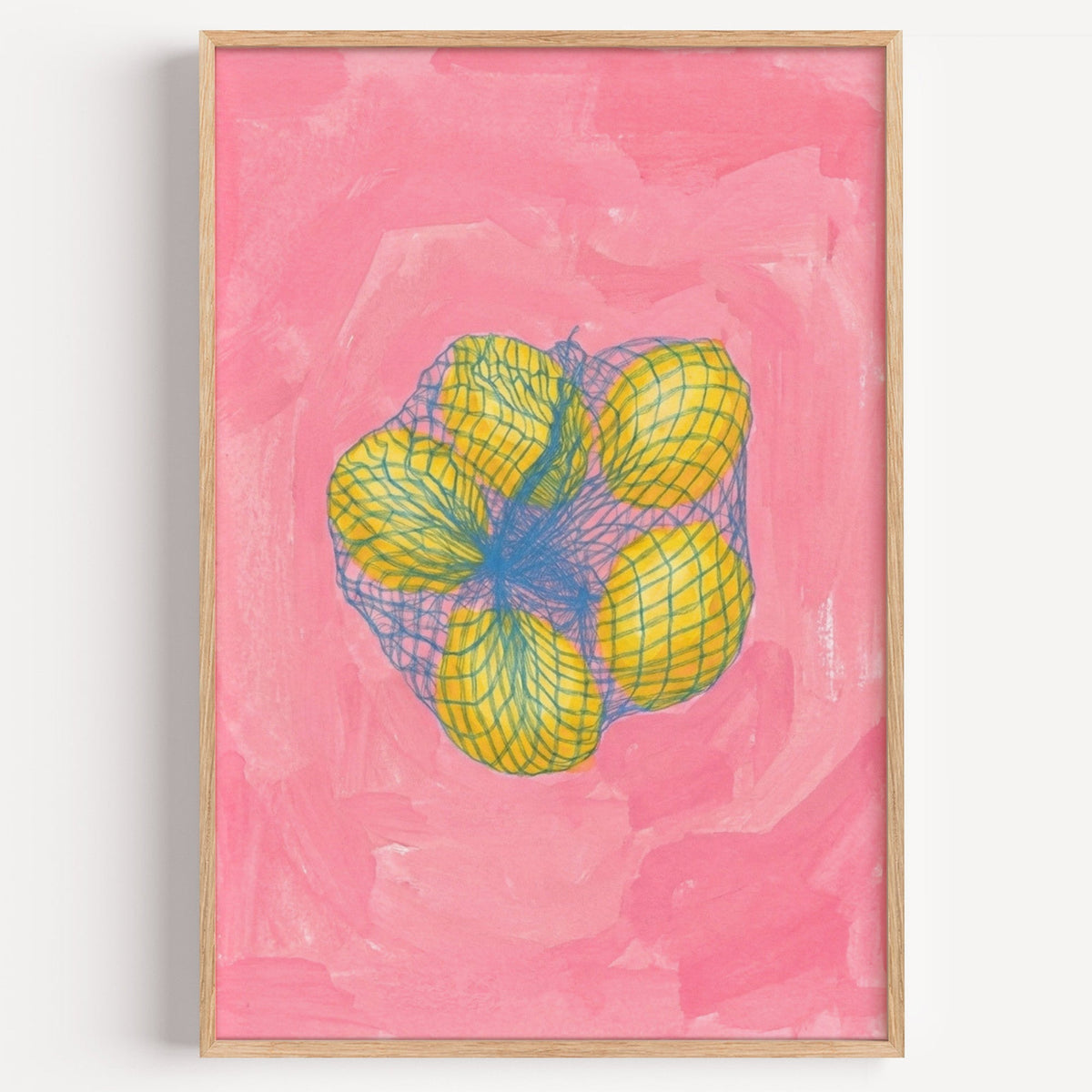 Lemons in mesh bag print in a light oak frame on a plain white wall