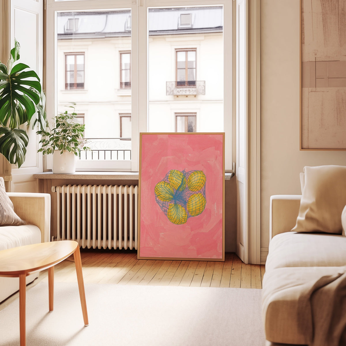 Pink lemon wall art print in an oak frame leaning below tall French windows
