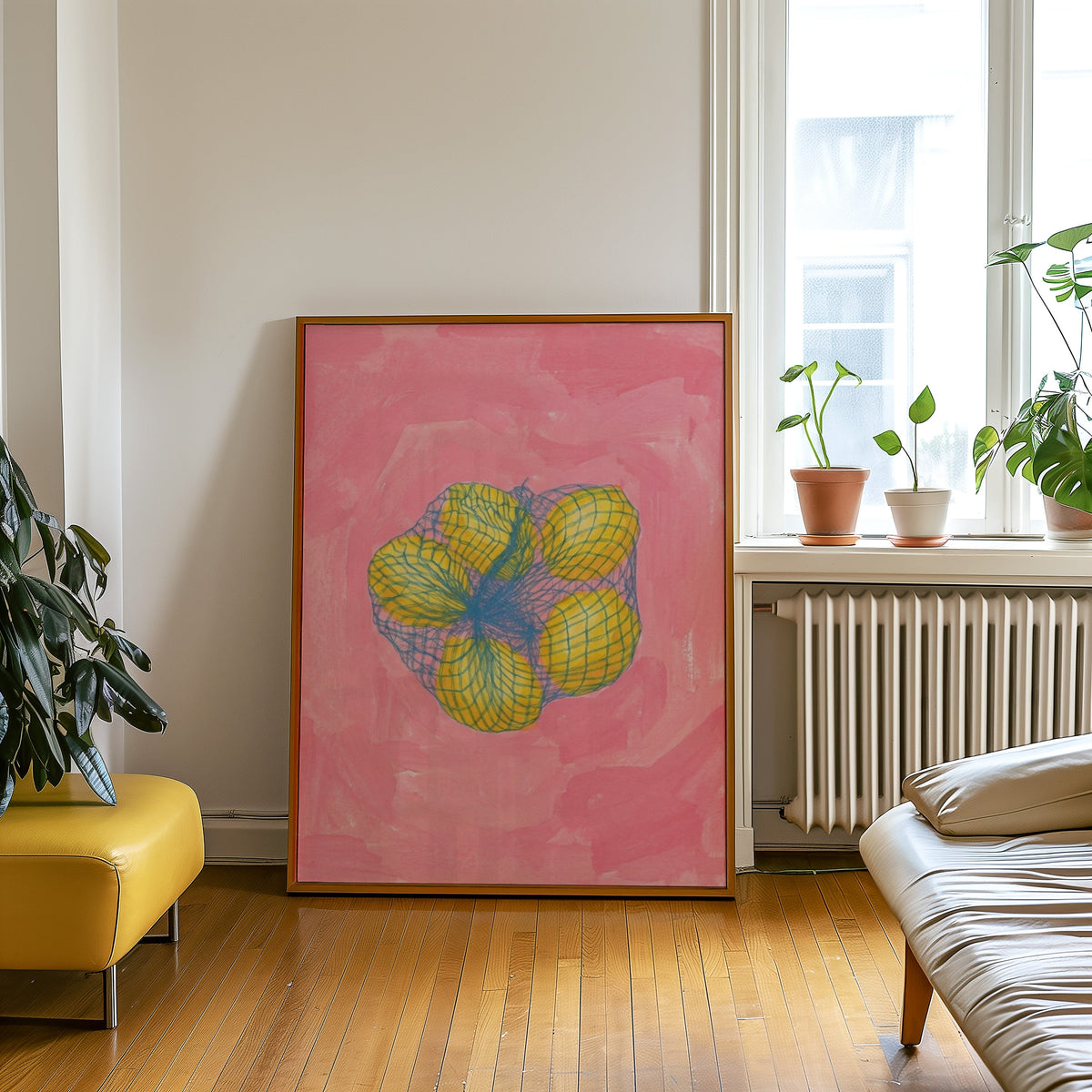 Lemon still life print in an oak frame leaning beside a yellow leather bench