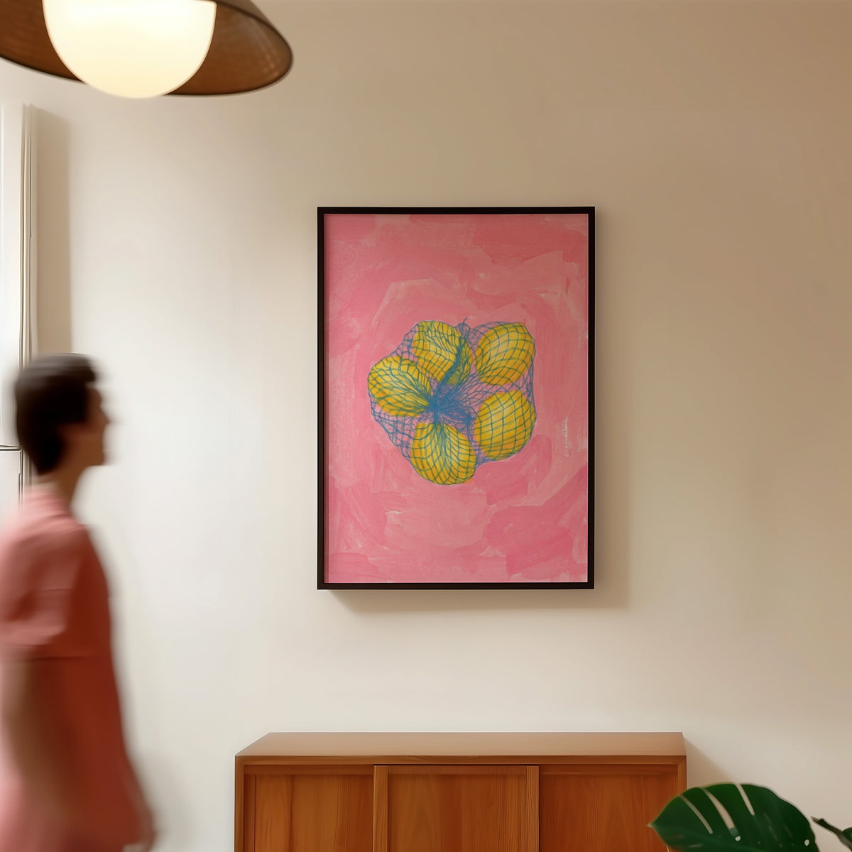 Market lemons print in a black frame in a hallway under a rattan pendant