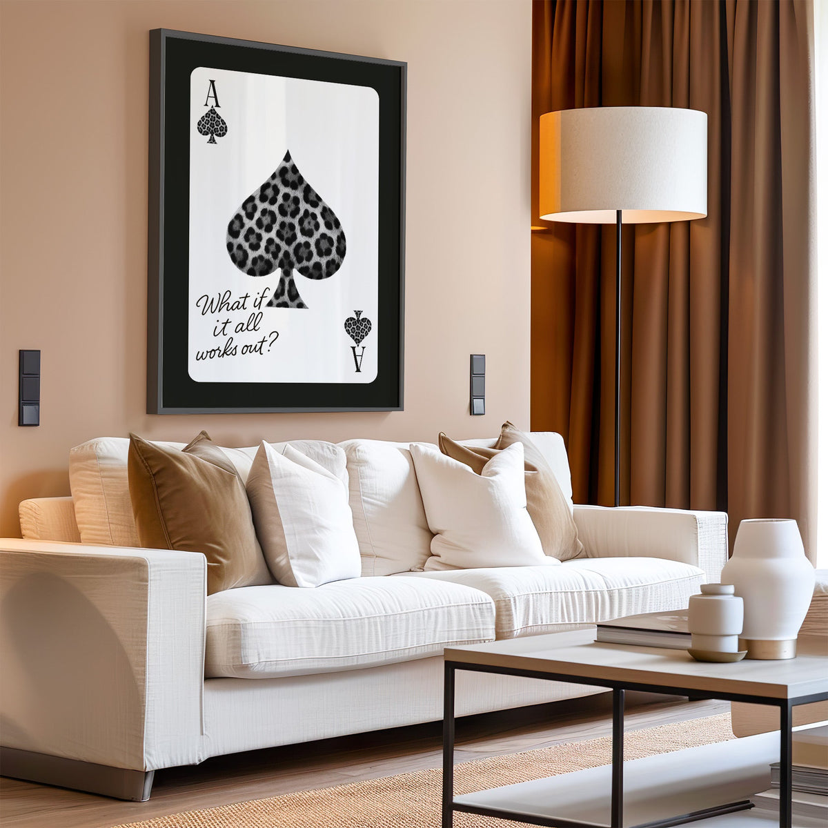 Leopard fur ace of spades card print in a black frame above a cream sofa on a blush living room wall