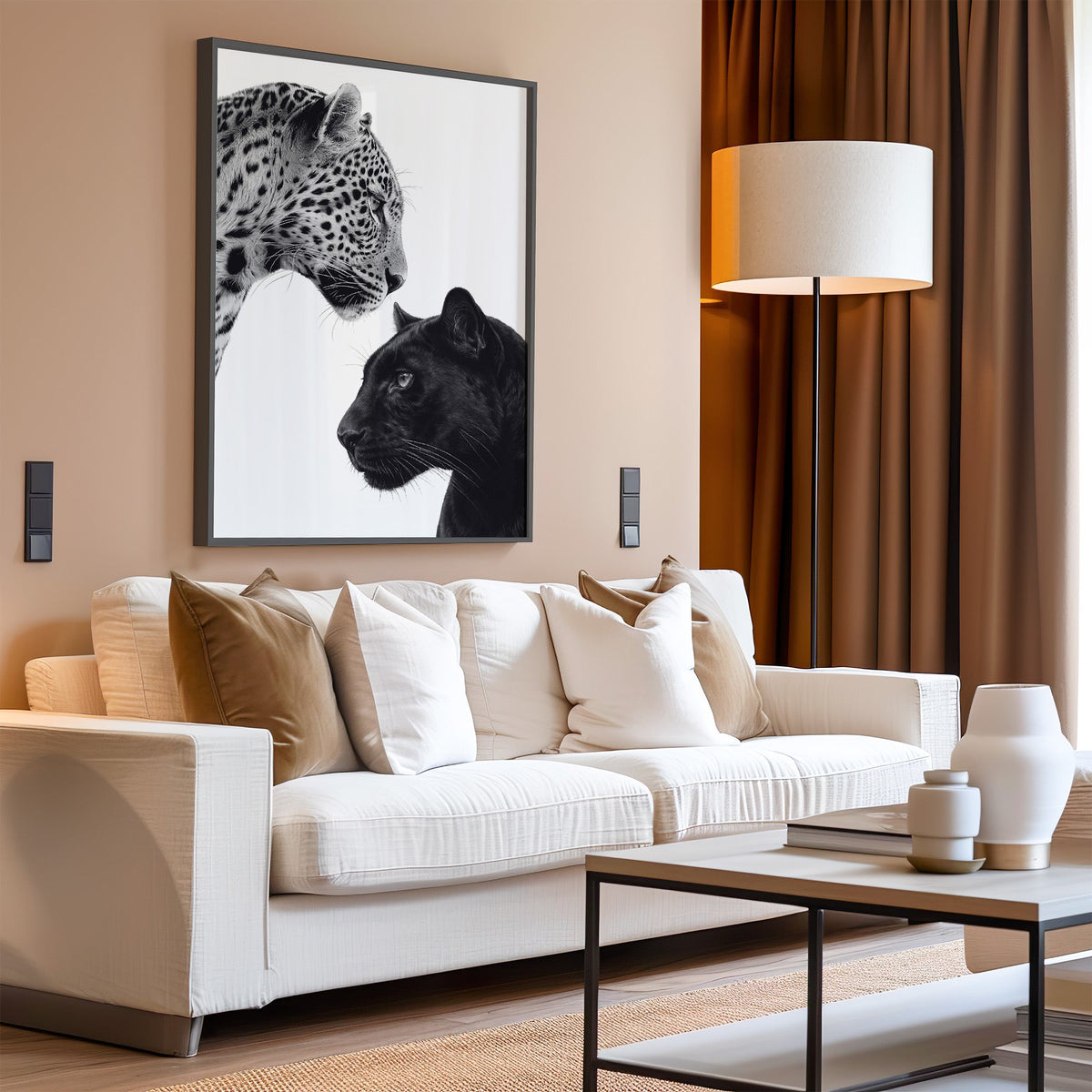 Leopard and black panther facing each other print in a black frame above a cream sofa on a blush living room wall