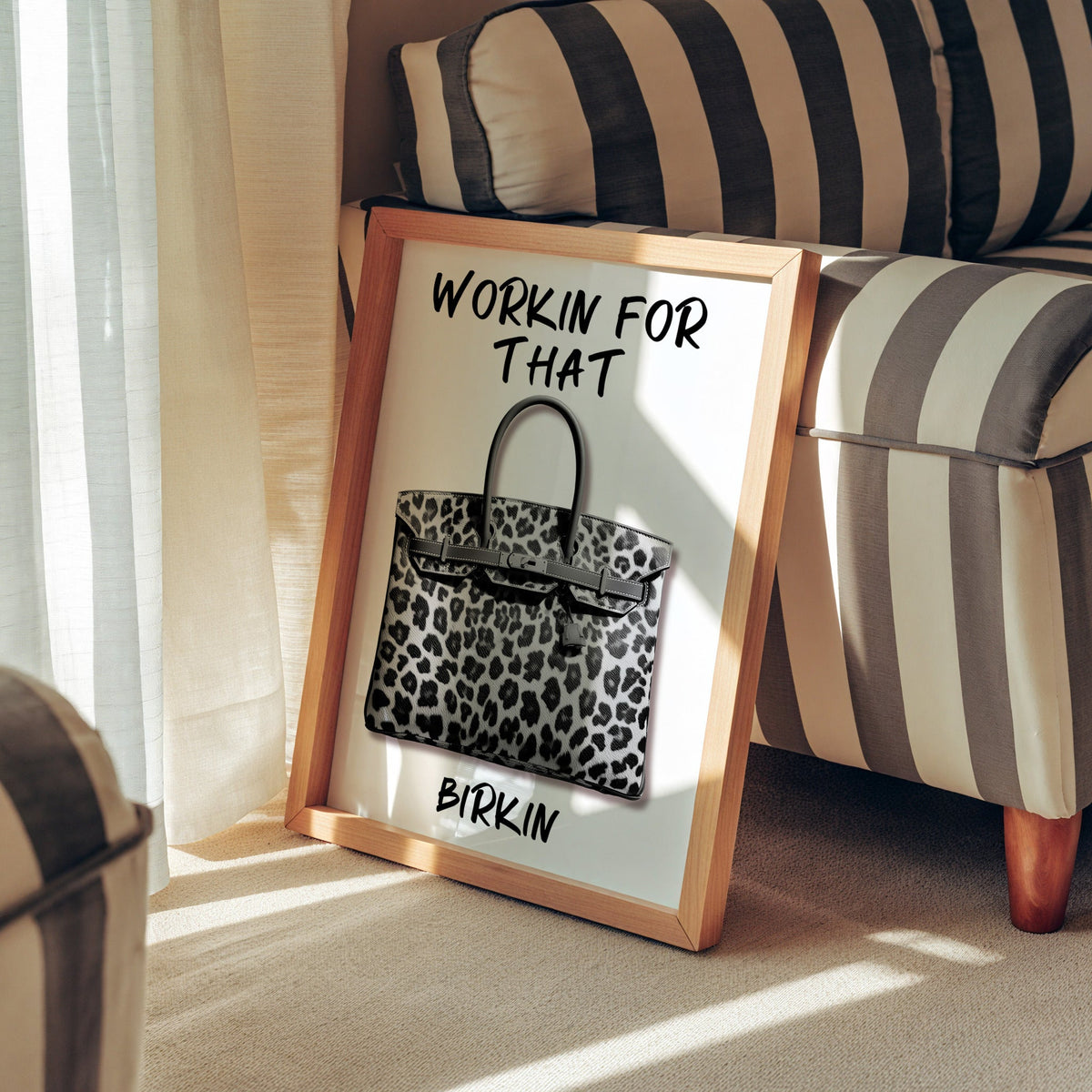 Leopard fur structured handbag with brush lettering print in a pine frame leaning against a striped armchair