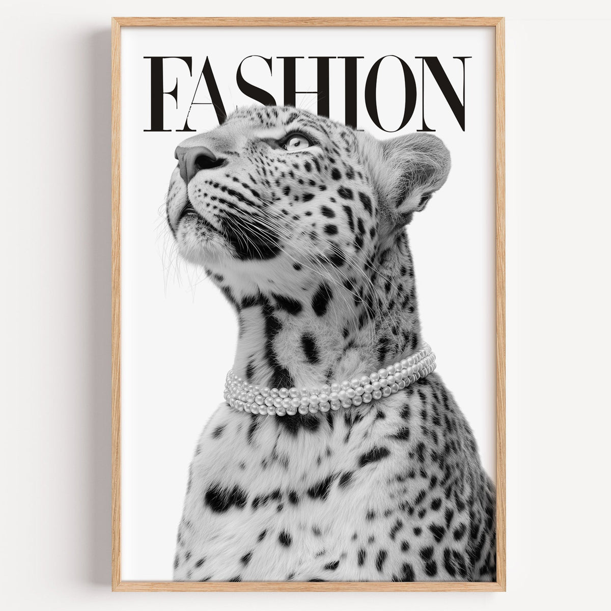 Leopard wearing pearl necklace fashion cover print in a light oak frame on a plain white wall