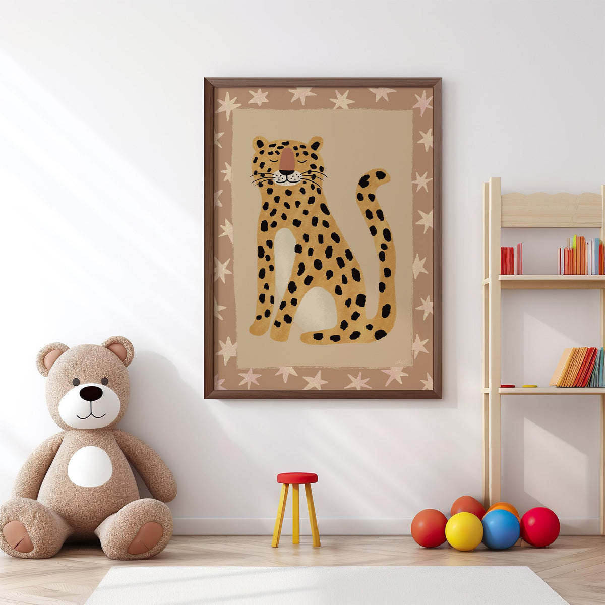 Smiling leopard with star border nursery print in a walnut frame above a big teddy bear by a bookshelf