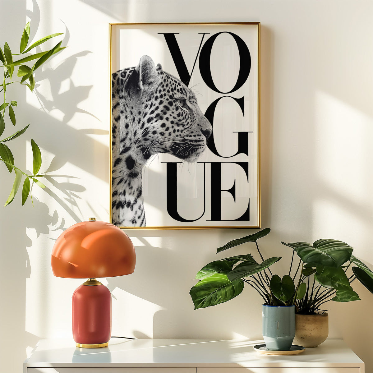 Leopard profile with serif lettering cover-style print shown in a gold frame above a white sideboard with an orange lamp