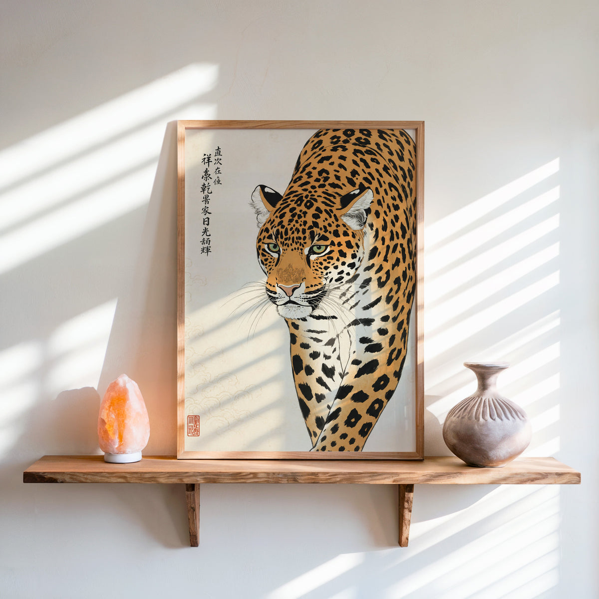 prowling leopard with calligraphy print in an oak frame on a live-edge wall shelf with a salt lamp and clay vase
