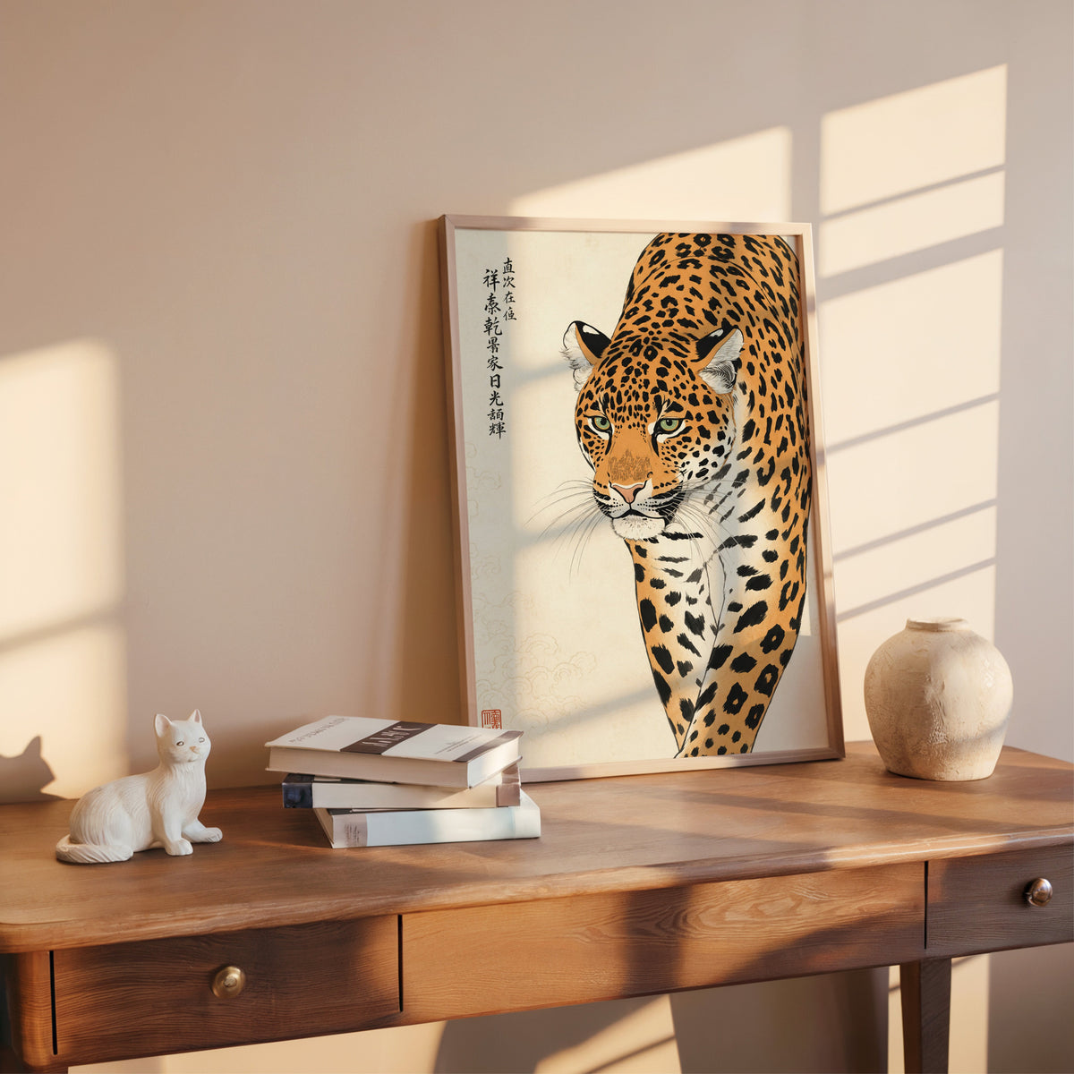prowling leopard with calligraphy print shown in a rose gold frame leaning on a wooden writing desk with books