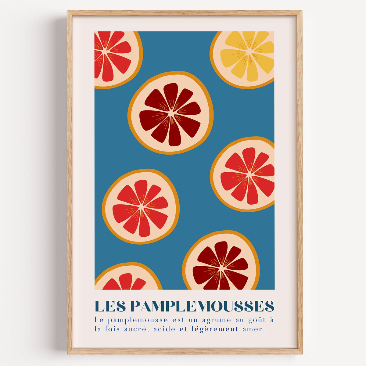 LES PAMPLEMOUSSES grapefruit slices petrol blue print in a light oak frame on a plain white wall