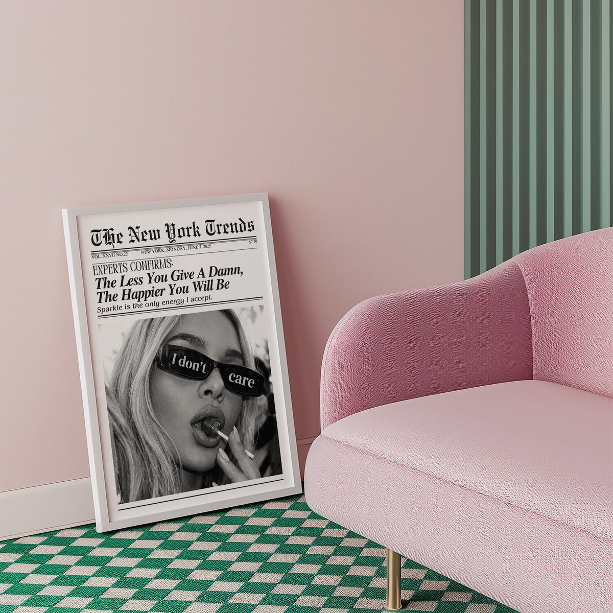 I don't care glasses and lollipop mock newspaper print in a white frame beside a pink armchair on a checkered floor