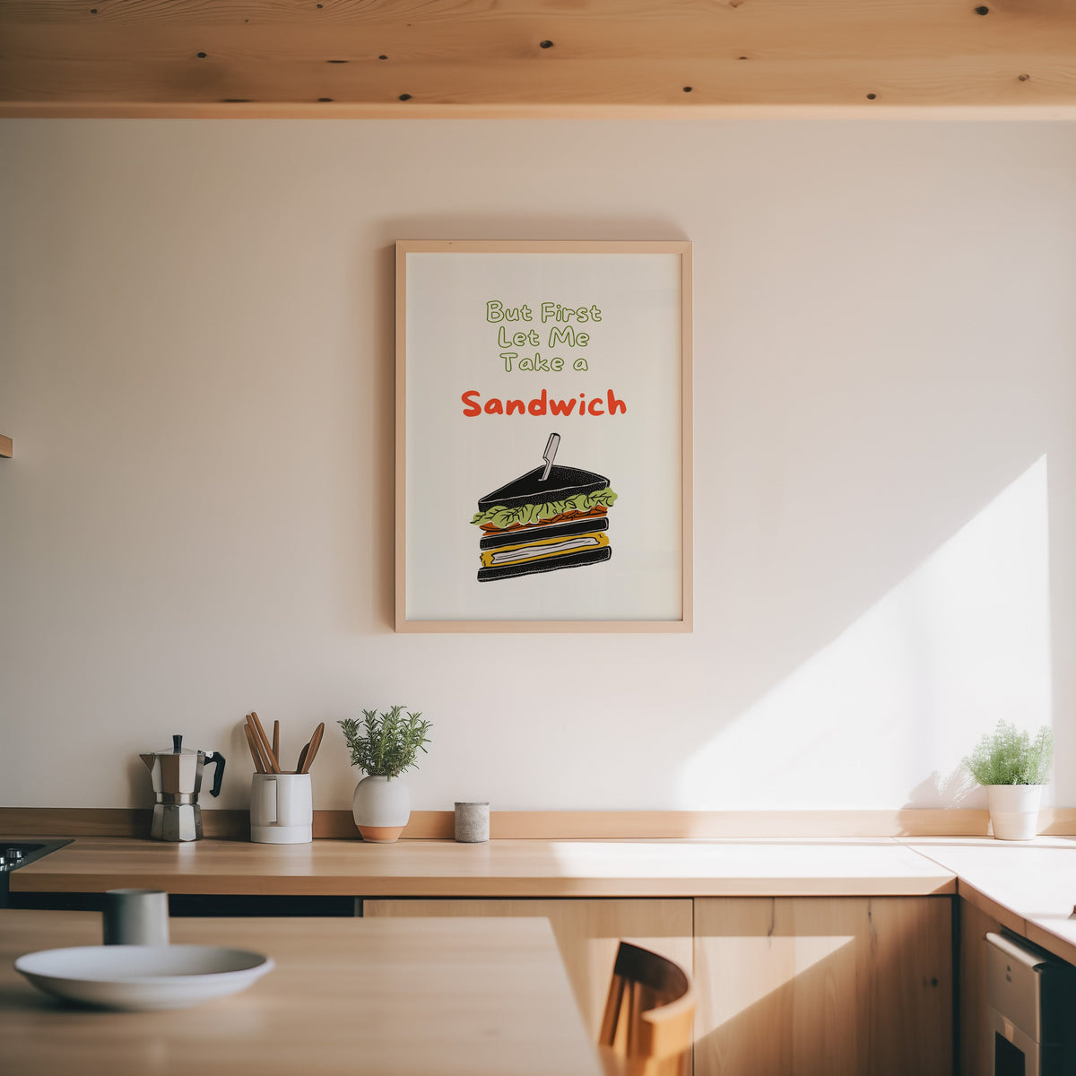 Club sandwich print in an oak frame above a wood counter with a moka pot and herbs