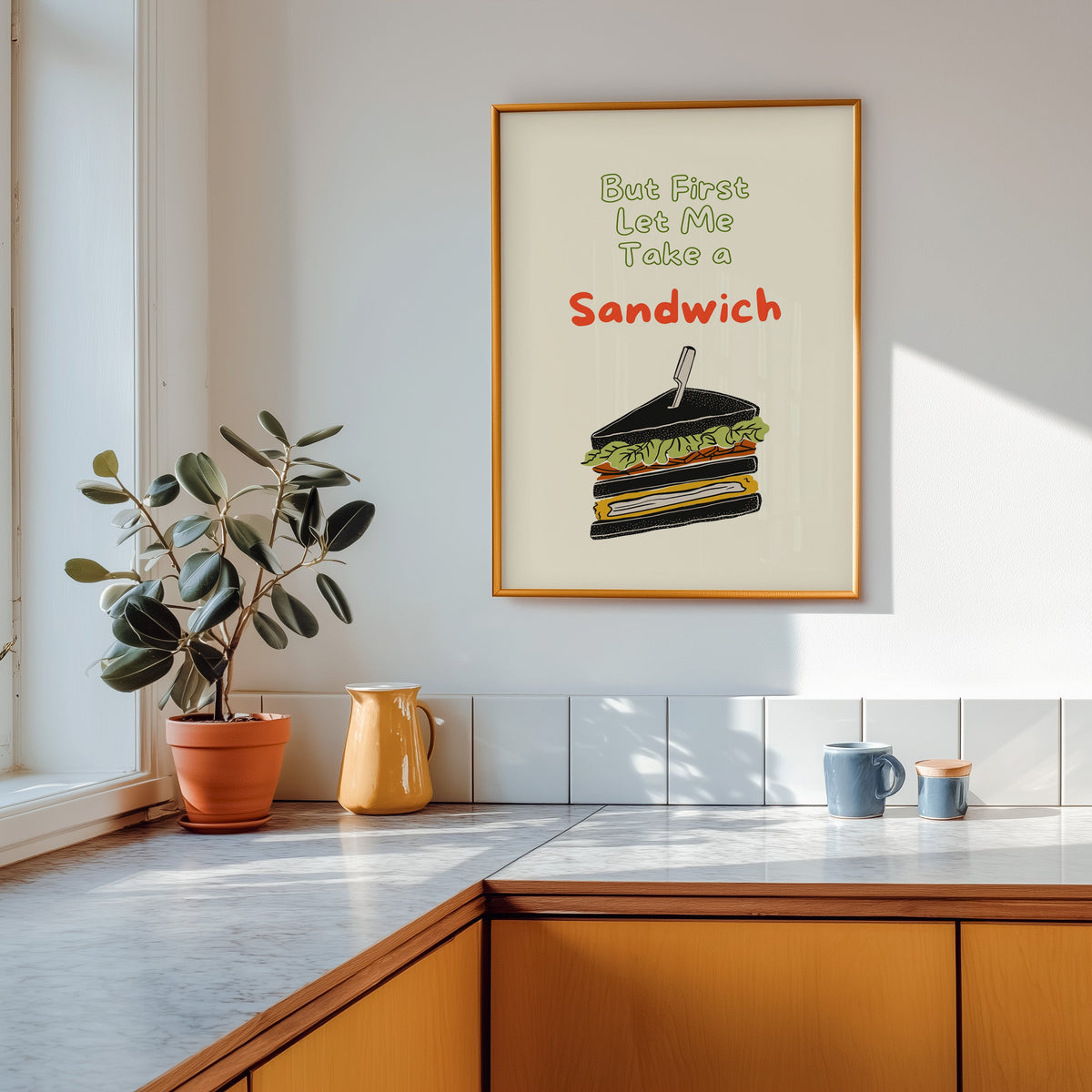 Club sandwich print shown in a gold frame above a marble counter with a yellow ceramic jug