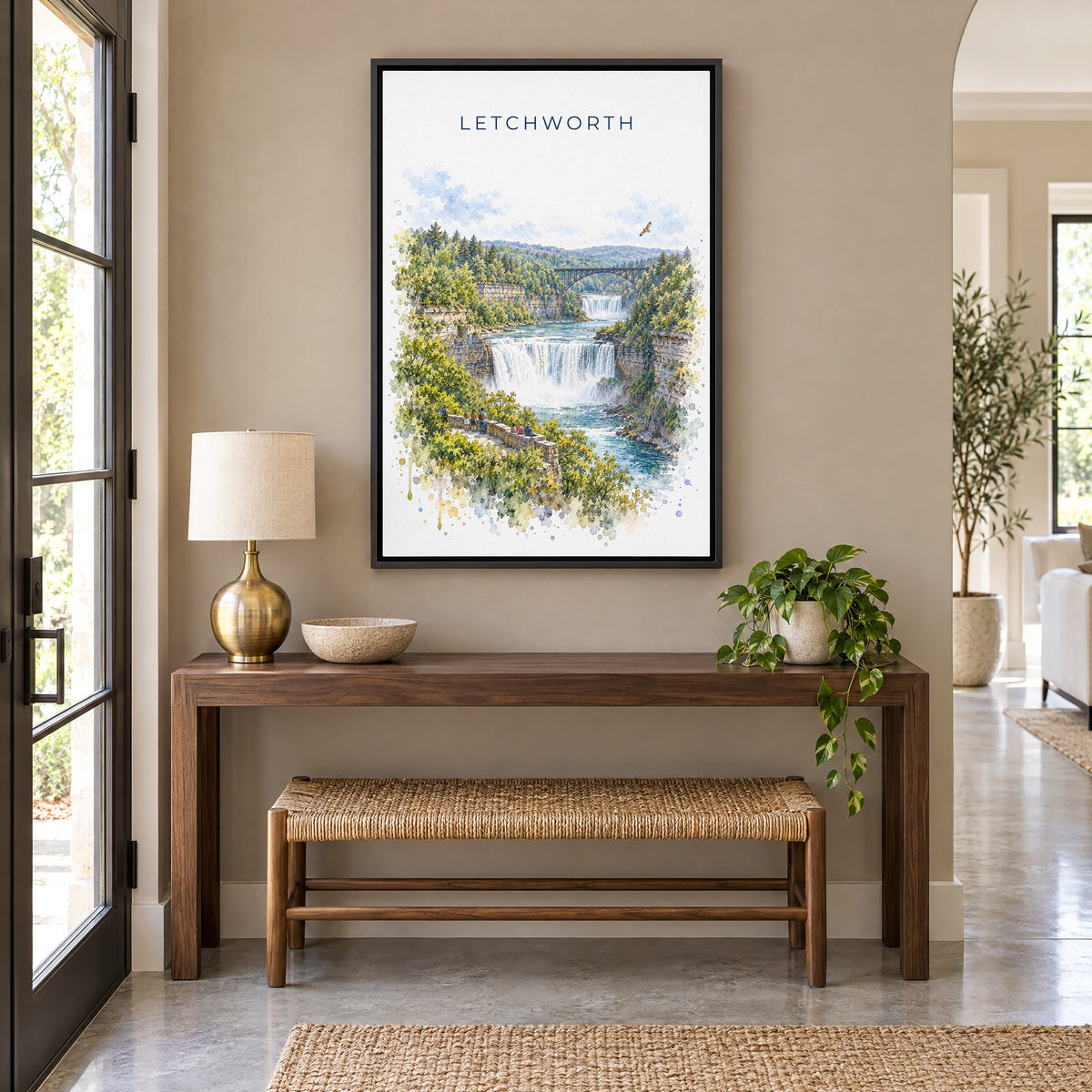 Letchworth State Park watercolor print as a black floater canvas above a walnut console and woven bench in an entryway