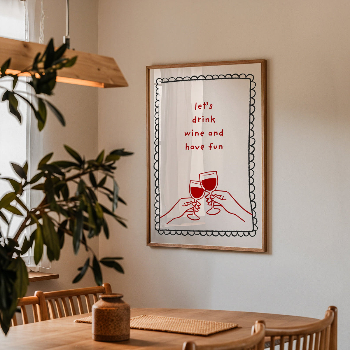Lets Drink Wine and Have Fun print in a walnut frame above a dining table with olive branches