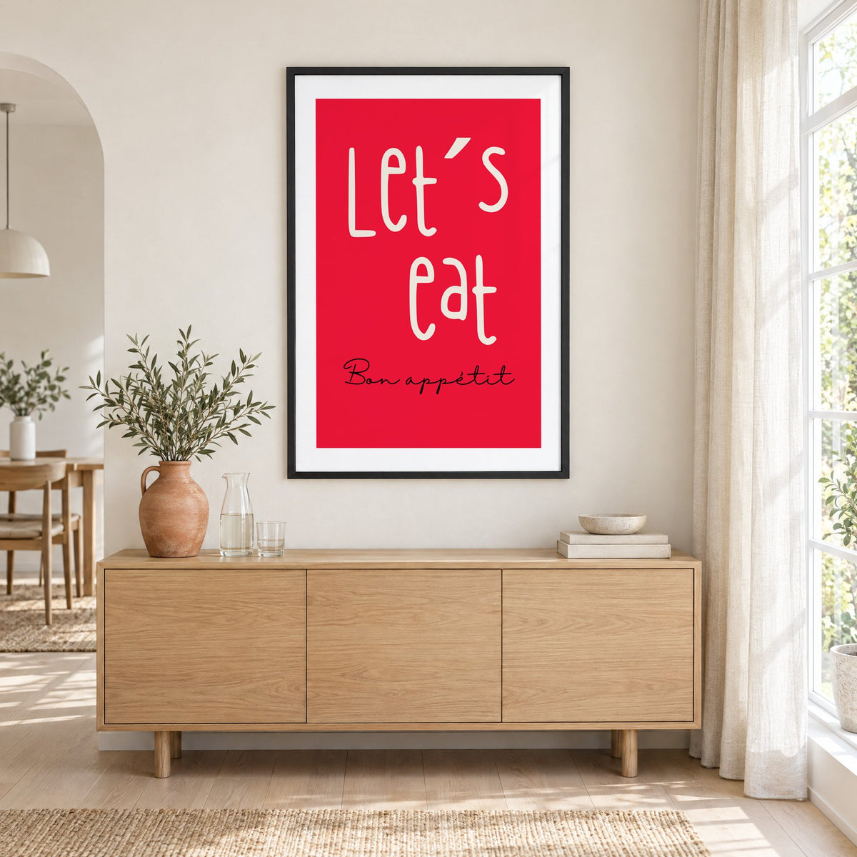 Let's eat red block print in a black frame above an oak sideboard with a terracotta vase of olive branches