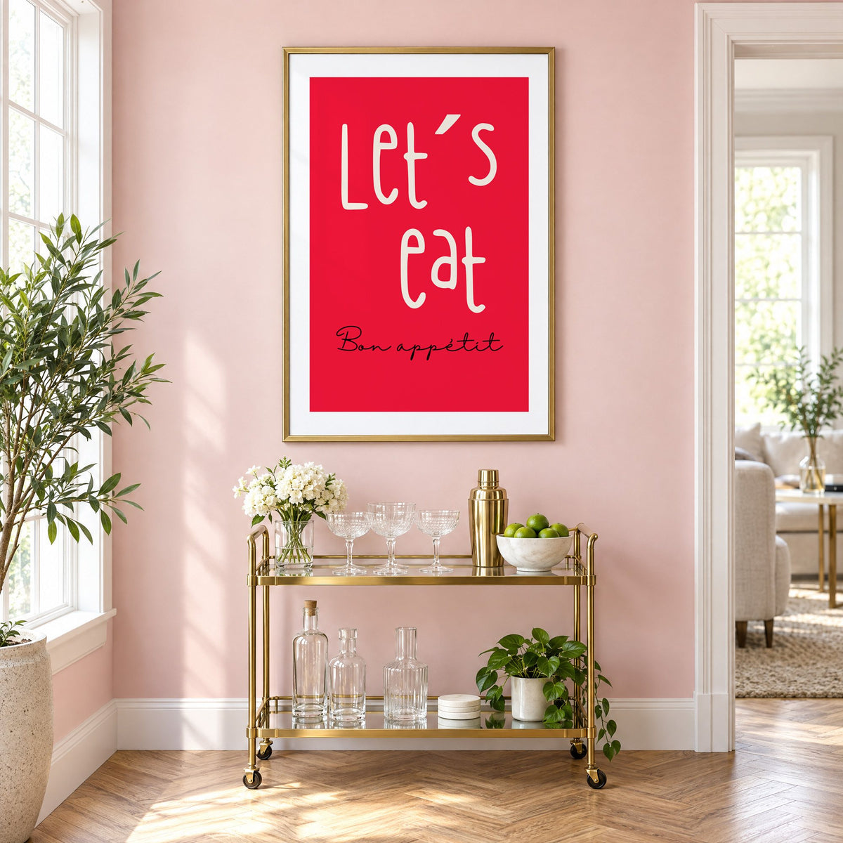 Let's eat red block print in a brass frame above a gold bar cart on a blush pink wall