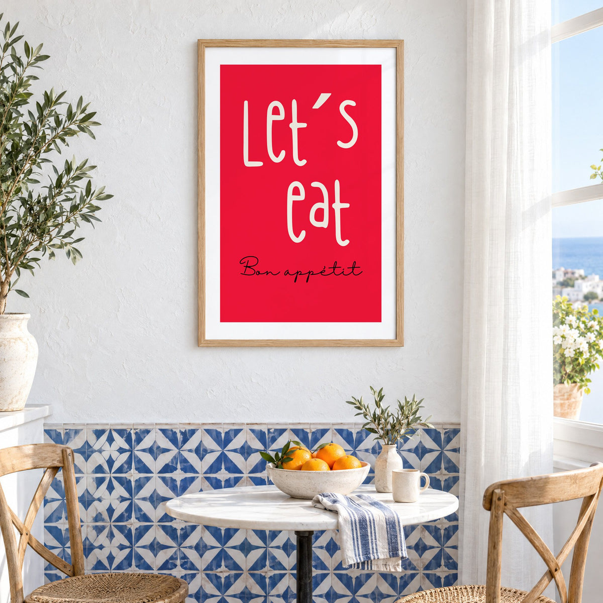 Let's eat red block print in an oak frame above a bistro table and blue patterned tiles