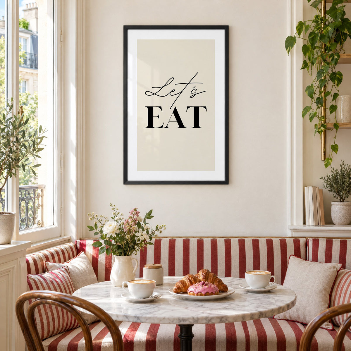 Let's EAT serif and script print in a black frame above a striped cafe breakfast nook with cappuccino and pastries