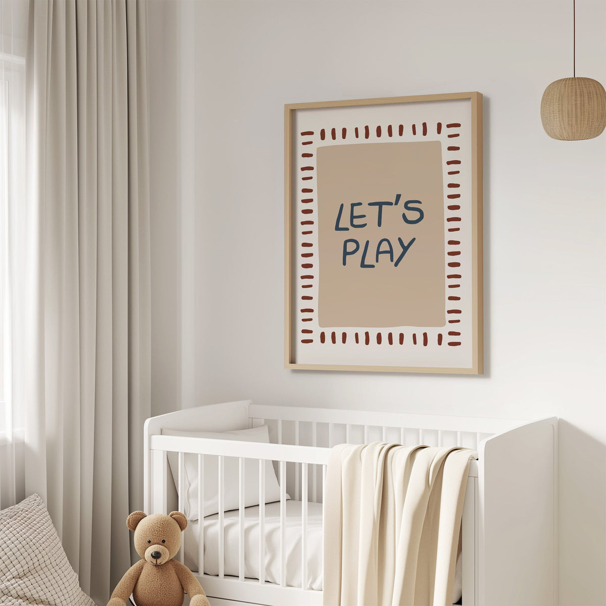 Lets play typography nursery print in an oak frame above a white crib with a teddy bear